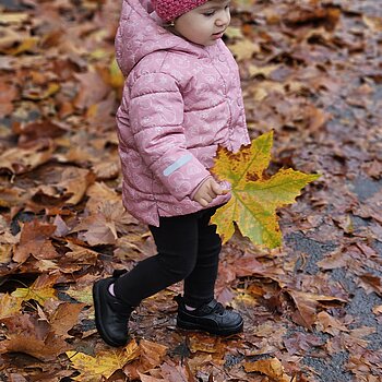 Moment surprins cand ea se juca cu frunzele intr-o zi de toamna ploioasa