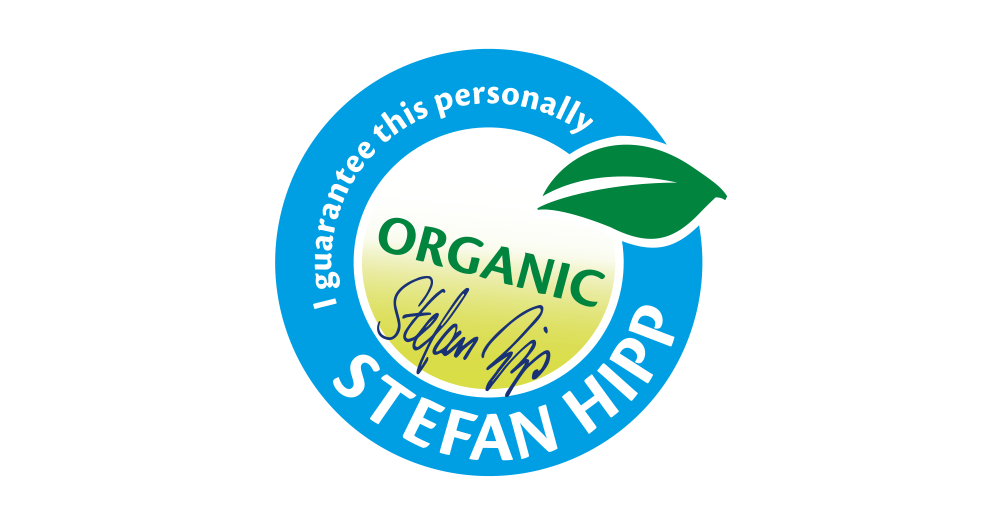 A circular badge with the word "ORGANIC" in the center, a green leaf symbol, and the name "STEFAN HIPP" written around the edge.