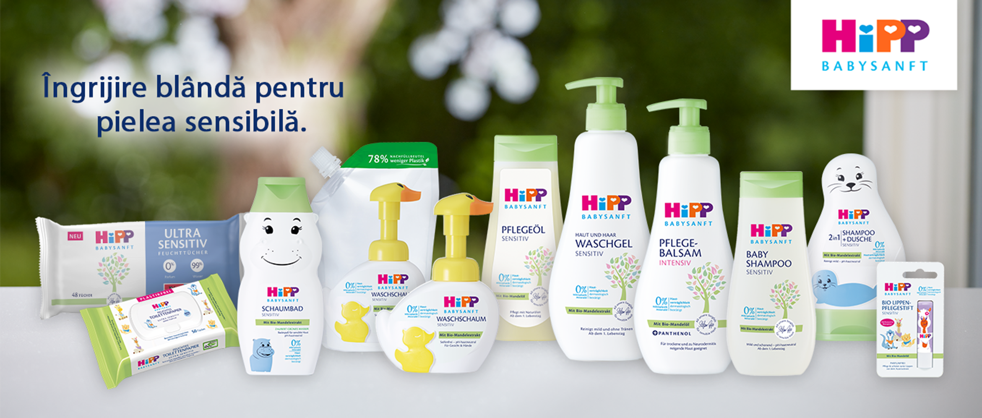 O colecție de produse de îngrijire pentru copii de la marca "Hipp", cu accent pe pielea sensibilă, însoțită de un slogan promoțional într-o limbă străină.