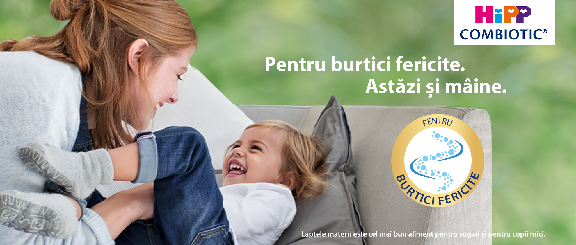 O femeie și un copil râzând sunt prezentați într-un cadru relaxat, cu un logo și un text care promovează un produs numit "HiPP Combiotic".